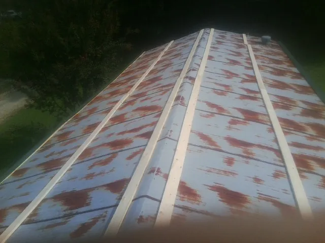 Rusted metal roof panels with new wood purlins before replacement — Storm Damage Roof Repair in Bernard by Roofing Brothers