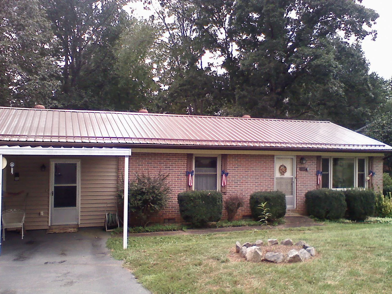 Bronze metal roof and carport on a brick ranch home — Roof Repair work by our crew in Bernard